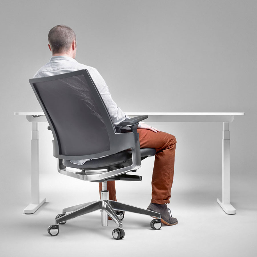fauteuil de bureau ergonomique avec roulettes et accoudoirs, gris, en situation avec dossier inclinable, avec un homme assis et devant un bureau