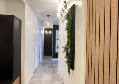 Couloir avec déco vgétal et avec armoires à chaussures et un banc